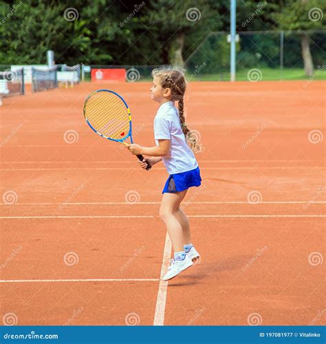 Теннис детей Девочка играет в теннис Стоковое Изображение изображение насчитывающей трудно