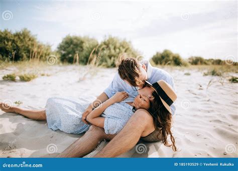 Young Couple Kissing On The Sea Beach At Sunrise The Concept Of Love And Summer Vacation Stock