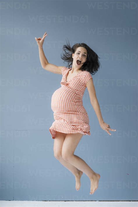 Woman Pretending To Be Pregnant Jumping For Joy Stock Photo