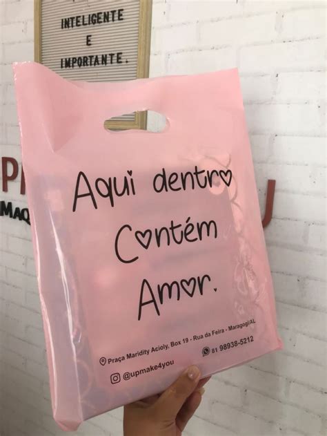 A Person Holding Up A Pink Plastic Bag That Says Aquai Denttry Contem