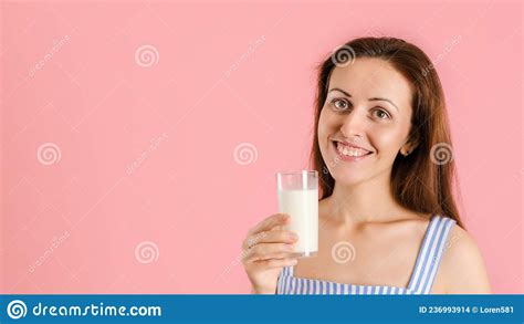 A Smiling Girl In A Blue Dress Holds A Glass Of Milk In Her Hands