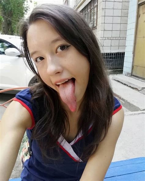 A Woman Sticking Her Tongue Out While Sitting On A Bench