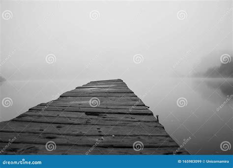 Wooden Footbridge On Lake With Thick Mist Foggy Air Over Water Early