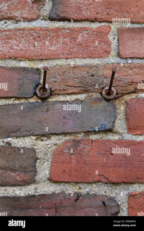 Two 2 Rusted Nails On Old Brick Wall Of Red Color Textured