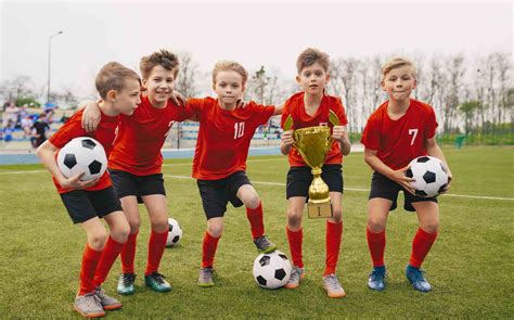 Happy Junior Sports Team Young Boys In Soccer Team Holding Golden Cup