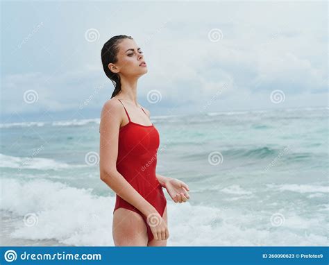 Beautiful Woman In A Red Swimsuit On The Ocean Beach With Wet Hair