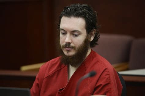 People embrace before a vigil for victims behind the photos: Colorado movie theater shooter James Holmes convicted of ...