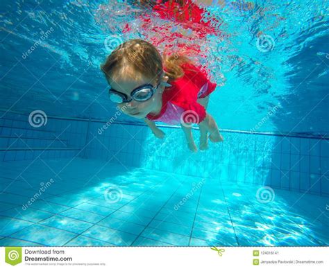 Funny Portrait Of Baby Girl Swimming And Diving In Blue Pool Stock