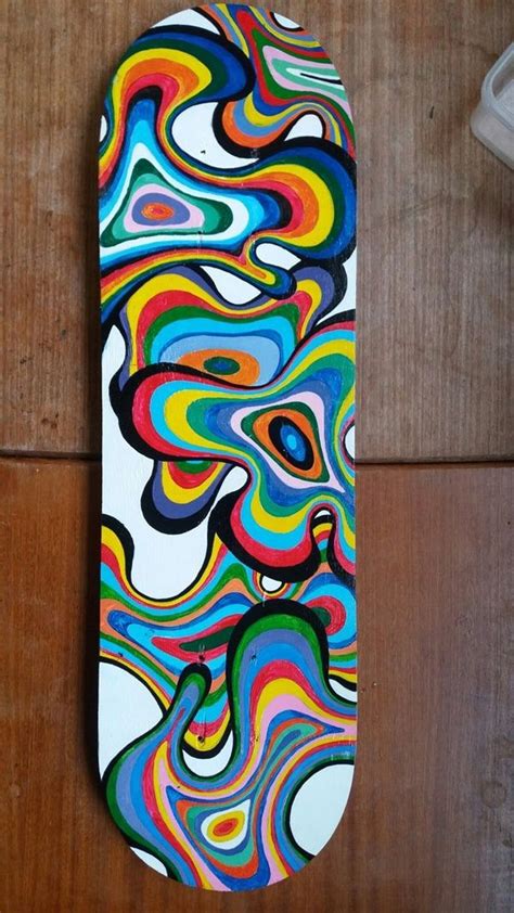 A Skateboard Is Painted With Multi Colored Swirls On Its Side