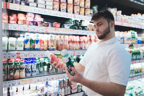 一个男人在超市的牛奶部挑选酸奶一个人在商店里买产品超高清图片下载 正版图片505051023 摄图网