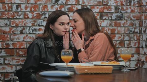 Young And Cheerful Girls Gossip And Whisper To Each Other While Sitting In A Cafe Stock Footage