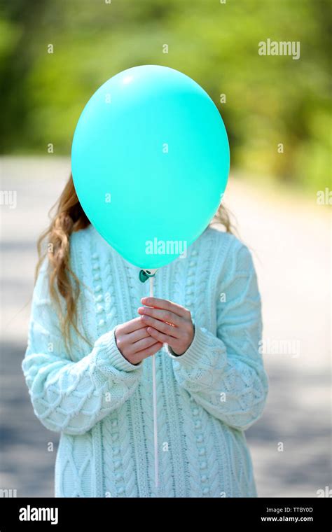 Girl Holding Balloon Near Face Stock Photo Alamy