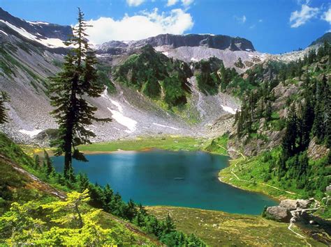 A Mountain Lake Surrounded By Pine Trees In The Middle Of A Valley With
