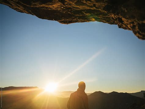 Man Hiking By The Sunset Under Cliff By Stocksy Contributor Martin Matej Stocksy