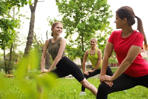 Women And Teenage Girl Doing Morning Exercise In Park Stock Photo