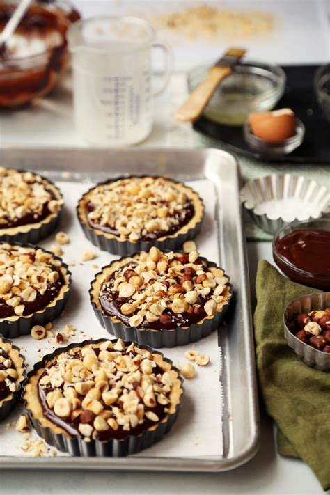 There Are Many Cupcakes On The Baking Sheet With Nuts And Chocolate In Them