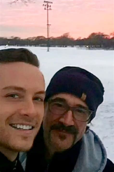 Two Men Standing Next To Each Other In The Snow