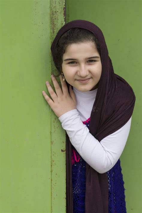 A Close Up Portrait Of A Beautiful Muslim Girl In Front Of A Green