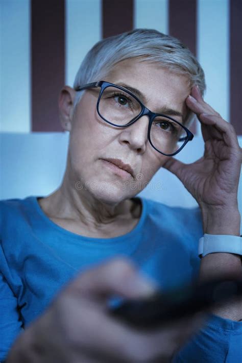 tired mature woman with sleeping problems watching television late at night stock image image