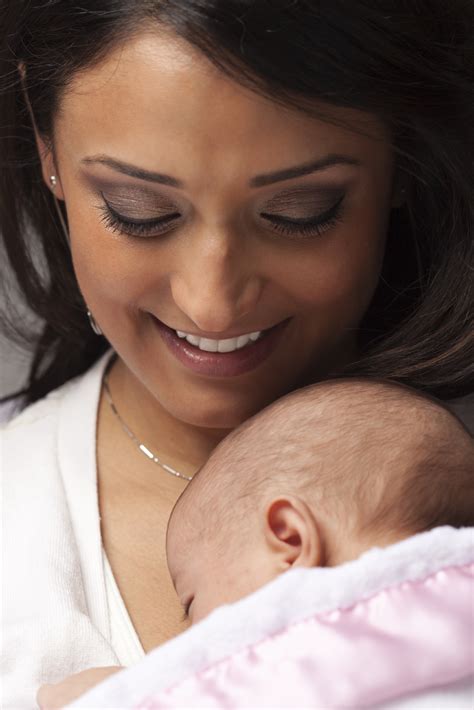 Young Attractive Ethnic Woman Holding Her Newborn Baby Under Dramatic