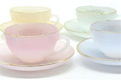 Three Different Colored Cups And Saucers Sitting Next To Each Other