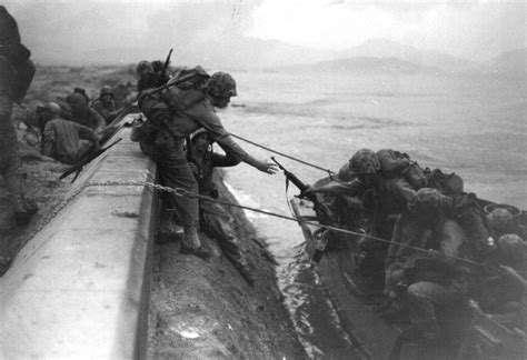 Us Marines Land From Assault Craft And Climb Over The Sea Defences At
