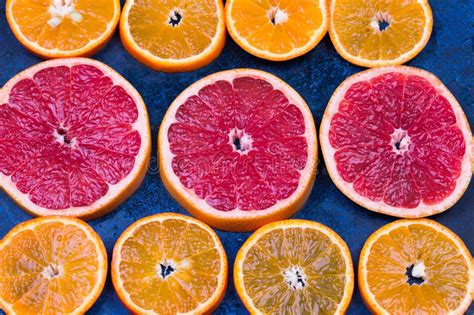 Fresh Oranges Grapefruits And Madarine Slices On Dark Stone Background