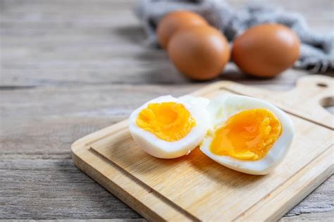 Huevos Cocidos Y Huevos Crudos En Una Mesa De Madera Foto Premium