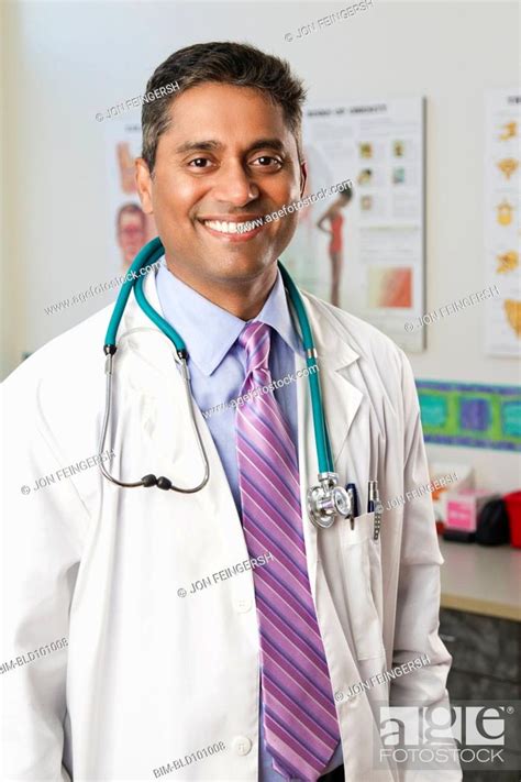 Smiling Indian Doctor In Doctors Office Stock Photo Picture And