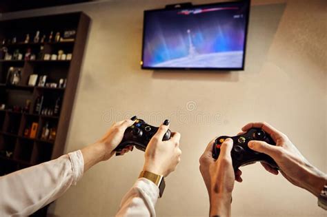 Playful Couple Gamers Enjoying Playing Video Games Indoors Sitting On