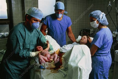 It was tough with one, god bless those parents! one mom wrote online, with another saying, congratulations! Baby being born in hospital - Stock Image - M810/0106 - Science Photo Library