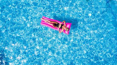 Woman Rest And Sunbath On A Float In The Pool Top View Aerial Shot