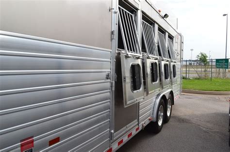 A Silver Horse Trailer Parked In A Parking Lot Next To Other Vehicles
