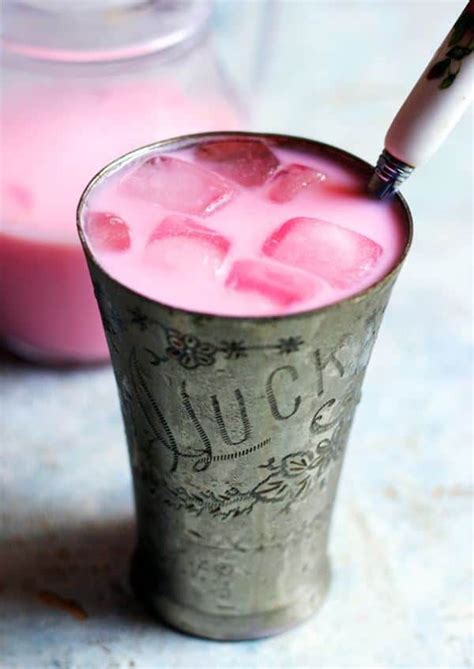 a pink drink with ice cubes in it