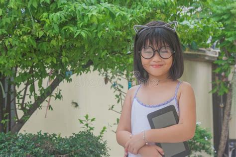 cute little asian chinese girl in glasses holding smartphone and smiling stock image image of