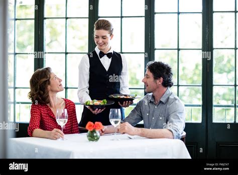 Waitress Serving Meal To A Couple Stock Photo Alamy