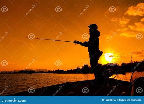 Picture Of A Fisherman Fishing On A Boat At Dusk Stock Image Image Of