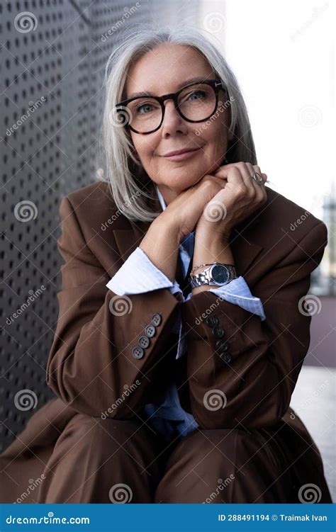 portrait of a well groomed slender senior business woman with gray hair dressed in an elegant