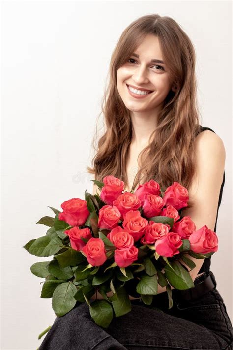 Young Attractive Girl With A Bouquet Of Red Roses On A White Background