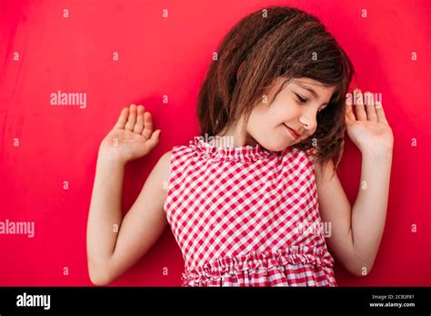 Little Brunette Girl Shrugging Hands In The Air Copy Space Isolated On Pink Background Stock
