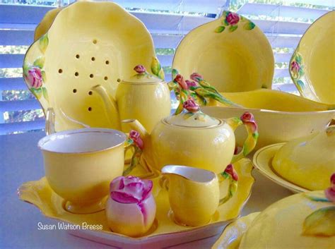 A Table Topped With Yellow Dishes Filled With Cups And Saucers Covered