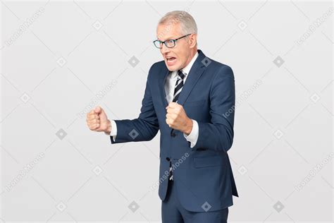 Angry Mature Businessman Holding Clenched Fists Up Photo
