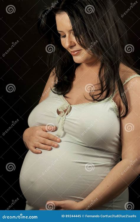 Beautiful Pregnant Brunette In Light Clothes Showing Signs Of Pr Stock