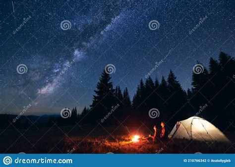 Couple Enjoying Starry Night Sky Near Campfire Stock Photo Image Of