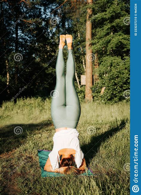 Slim Athletic Young Woman Practicing Yoga Asana Headstand Rear View