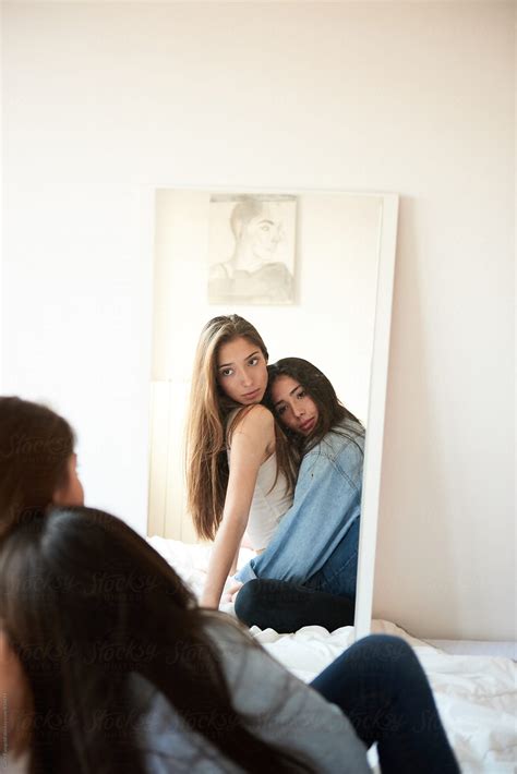two girlfriends looking in the mirror while hugging by stocksy contributor guille faingold