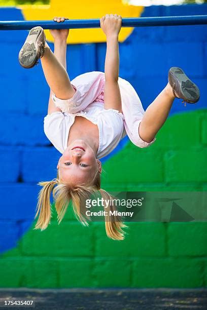 Girl Hanging Upside Down In A Playground Photos And Premium High Res