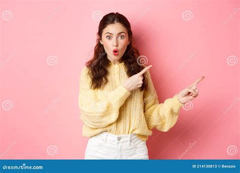 Portrait Of Surprised Brunette Girl Gasping Impressed Pointing Fingers Right At Copy Space