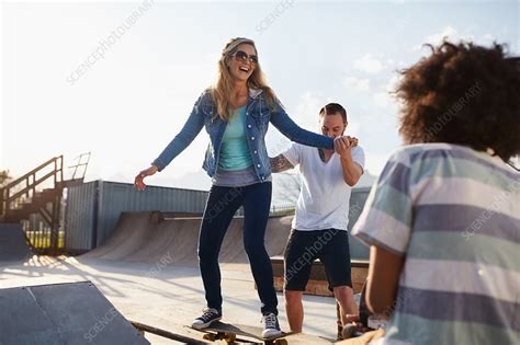 Boyfriend Helping Girlfriend On Skateboard Stock Image F0180396