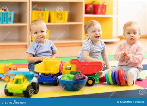 Group Of Babies Is Playing On Floor In Nursery Children In The Day